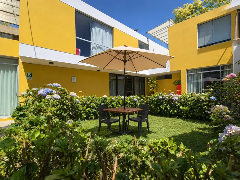 Courtyard with hydrangeas in front of the hotel’s yellow façade